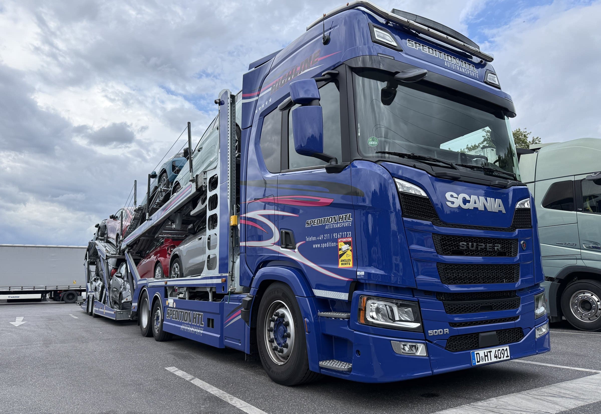 Scania-Autotransporter von Spedition HTL mit Fahrzeugen beladen, Dreiviertelansicht